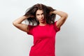 Young, beautiful girl has a disheveled hair, a bad day for hair, isolated on a light background. Different human emotions, Royalty Free Stock Photo