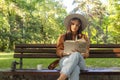 A young woman is sitting on a park bench with the book in her hands Royalty Free Stock Photo