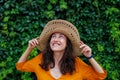 young and beautiful girl in a hat and yellow dress smiles at the camera. happy girl on vacation Royalty Free Stock Photo