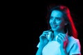 Young beautiful girl in headphones isolated on dark background in neon light Royalty Free Stock Photo