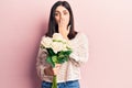 Young beautiful girl holding bouquet of flowers covering mouth with hand, shocked and afraid for mistake Royalty Free Stock Photo