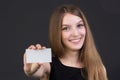 Young beautiful girl holding a business card in hand Royalty Free Stock Photo