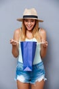 young beautiful girl holding colorful bags over gray background. Royalty Free Stock Photo