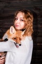 A young beautiful girl holding a wild fox animal that was traumatized by a man and rescued by her and now lives as before