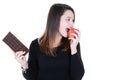 Young beautiful girl holds and choosing chocolate or apple Isolated white background portrait in studio in concept of healthy and Royalty Free Stock Photo