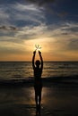 Young, beautiful the girl holds the starfish on the background of the sunset at the sea shore Royalty Free Stock Photo