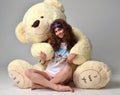 Young beautiful girl hugging big teddy bear soft toy happy smiling Royalty Free Stock Photo