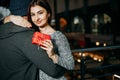 Young beautiful girl hugging her boyfriend with gift box in hand Royalty Free Stock Photo