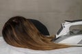 Young beautiful girl ironing her hair on an ironing board Royalty Free Stock Photo