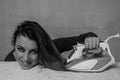 Young beautiful girl ironing her hair on an ironing board Royalty Free Stock Photo