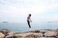 Young beautiful girl jumping upwards portraying a flight against the background of the sea and sky. The concept of Royalty Free Stock Photo