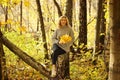 Young beautiful girl in a knitted sweater on the background of autumn park with fallen leaves Royalty Free Stock Photo