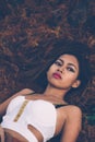 Young beautiful girl laying on the forest floor, with hair tangled in small branches that felled from pine trees, fashion concept Royalty Free Stock Photo