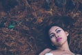 Young beautiful girl laying on the forest floor, with hair tangled in small branches that felled from pine trees, fashion concept Royalty Free Stock Photo