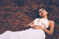 Young beautiful girl laying on the forest floor, with hair tangled in small branches that felled from pine trees, fashion concept Royalty Free Stock Photo