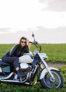 Young beautiful girl in leather clothes posing on a motorcycle