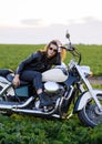 Young beautiful girl in leather clothes posing on a motorcycle