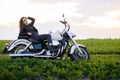 Young beautiful girl in leather clothes posing on a motorcycle