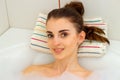 Young beautiful girl lies in a hot tub with foam Royalty Free Stock Photo