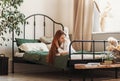 A young beautiful girl with long hair on a bed . Woman enjoying morning awakening . The concept of home coziness and comfort Royalty Free Stock Photo