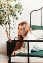 A young beautiful girl with long hair on a bed . Woman enjoying morning awakening . The concept of home coziness and comfort Royalty Free Stock Photo