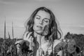 Young beautiful girl with long hair during a walk on a hot summer sunny day over a poppy field enjoying the aroma of a poppy flowe Royalty Free Stock Photo