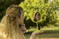 Young beautiful girl look into mirror in the park.Soft and blur conception. Royalty Free Stock Photo