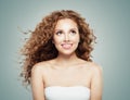 Young beautiful girl looking up. Cute woman with long healthy curly hair on gray background Royalty Free Stock Photo