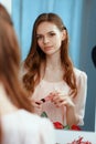 Young beautiful girl makes herself a makeup in front of a mirror Royalty Free Stock Photo