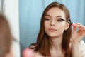 Young beautiful girl makes herself a makeup in front of a mirror Royalty Free Stock Photo