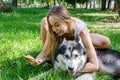 Young beautiful girl makes selfie with a dog in the park. Royalty Free Stock Photo