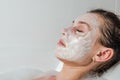 Young beautiful girl makes a white face mask for beauty during spa treatments in the bathroom Royalty Free Stock Photo