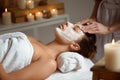 Young beautiful girl in mask for face relaxing in spa salon. Royalty Free Stock Photo