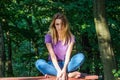 Young beautiful girl model in jeans and a T-shirt with long blond hair and sad smiles pensively posing for a walk in the autumn pa Royalty Free Stock Photo