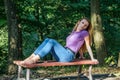 Young beautiful girl model in jeans and a T-shirt with long blond hair and sad smiles pensively posing for a walk in the autumn pa Royalty Free Stock Photo