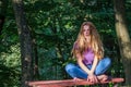 Young beautiful girl model in jeans and a T-shirt with long blond hair and sad smiles pensively posing for a walk in the autumn pa Royalty Free Stock Photo
