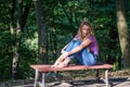 Young beautiful girl model in jeans and a T-shirt with long blond hair and sad smiles pensively posing for a walk in the autumn pa Royalty Free Stock Photo