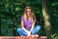 Young beautiful girl model in jeans and a T-shirt with long blond hair and sad smiles pensively posing for a walk in the autumn pa Royalty Free Stock Photo