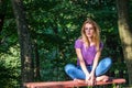 Young beautiful girl model in jeans and a T-shirt with long blond hair and sad smiles pensively posing for a walk in the autumn pa Royalty Free Stock Photo