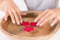 Beautiful female natural manicure nails and wooden bowl with water Royalty Free Stock Photo