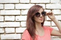 Young beautiful girl near white brick wall, street style, place Royalty Free Stock Photo