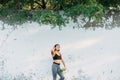 A young beautiful girl near a white wall in sportswear drinks water from a bottle. in the summer time Royalty Free Stock Photo