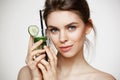 Young beautiful girl with perfect clean skin smiling looking at camera holding glass of water with cucumber slices over Royalty Free Stock Photo