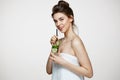 Young beautiful girl with perfect clean skin smiling looking at camera holding glass of water with cucumber slices over Royalty Free Stock Photo