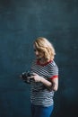 Young beautiful girl photographer with a camera in her hands in a photo studio. Women`s work is a hobby. Soft selective focus Royalty Free Stock Photo