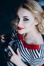 Young beautiful girl photographer with a camera in her hands in a photo studio. Women`s work is a hobby. Soft selective focus. Royalty Free Stock Photo