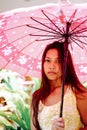 Young beautiful girl with the pink umbrella on sunny day