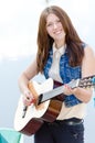 Young beautiful girl playing guitar happy smiling Royalty Free Stock Photo