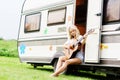 Young and beautiful girl playing guitar outdoors. Royalty Free Stock Photo