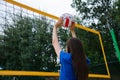 Young beautiful girl playing volleyball on the beach in summer, hitting the ball Royalty Free Stock Photo